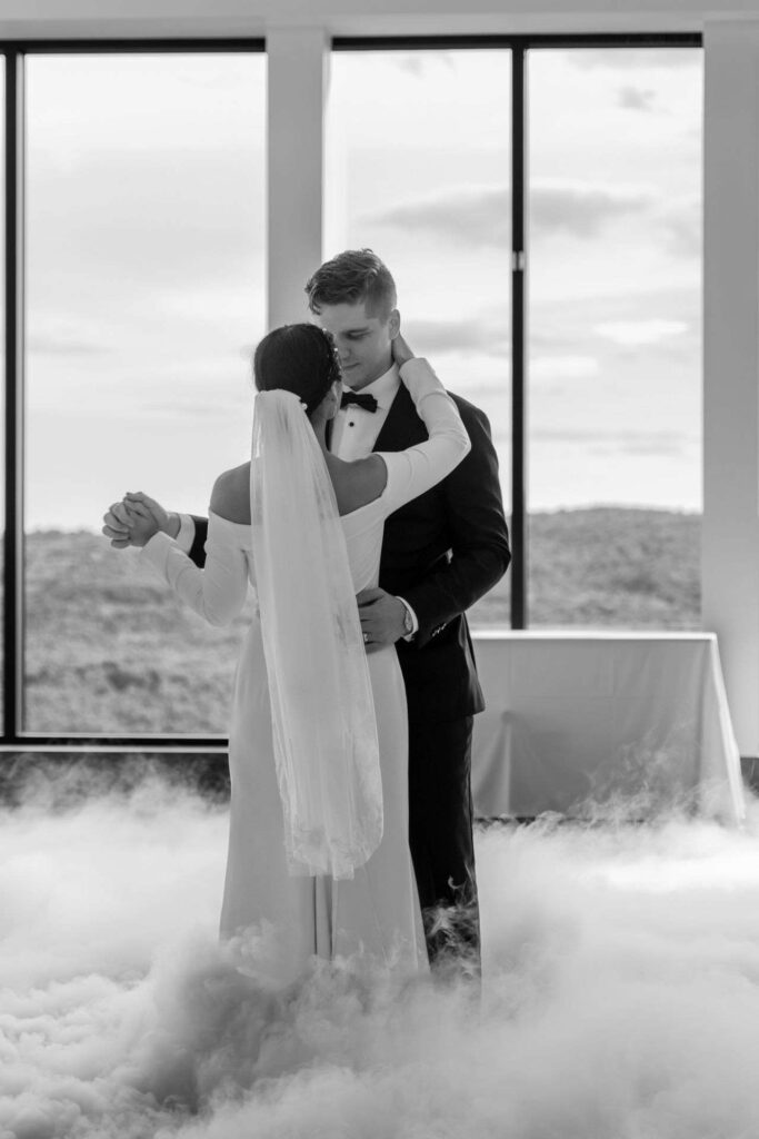 Premier danse des mariés dans la brume, photo de mariage noir et blanc.