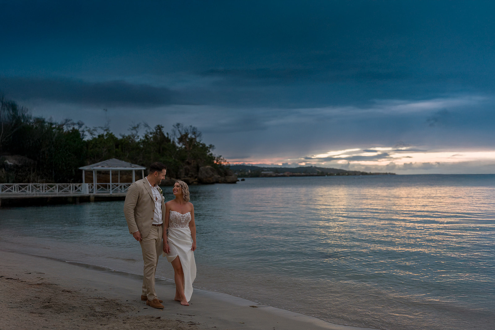 Mariés se regardant sur une plage au crépuscule, mariage à destination dans le sud