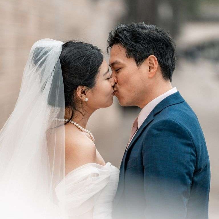 Mariés s'embrassant devant un bâtiment historique — photographe mariage Montréal.