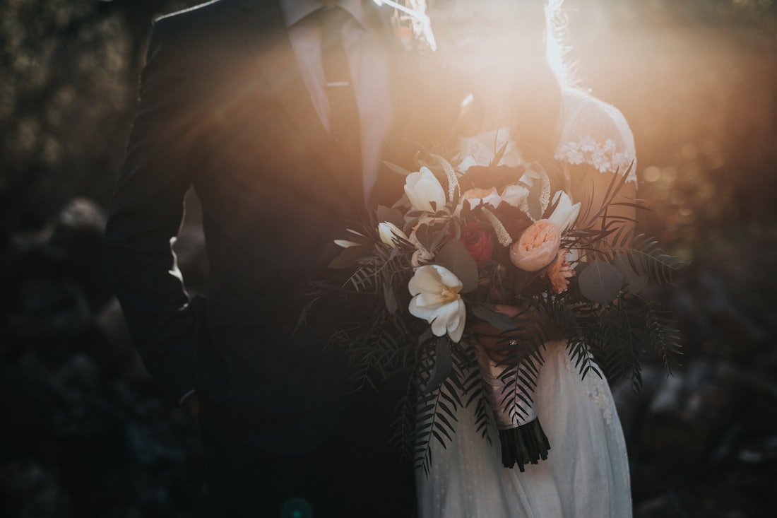 hotographe de mariage à Montréal capturant le bouquet de la mariée au coucher du soleil.